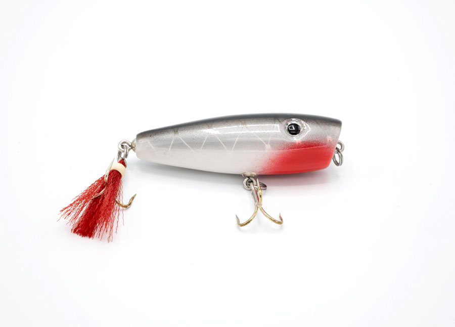 Side view of JL Lures silver & gray with red tassel pine wood fishing lure