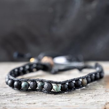 Front view of the camouflage surf rider bracelet by Lotus and Luna on a rustic wooden backdrop