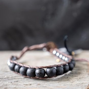 Front view of the Nomad Moonless Night men's bracelet by Lotus and Luna on a rustic wooden backdrop