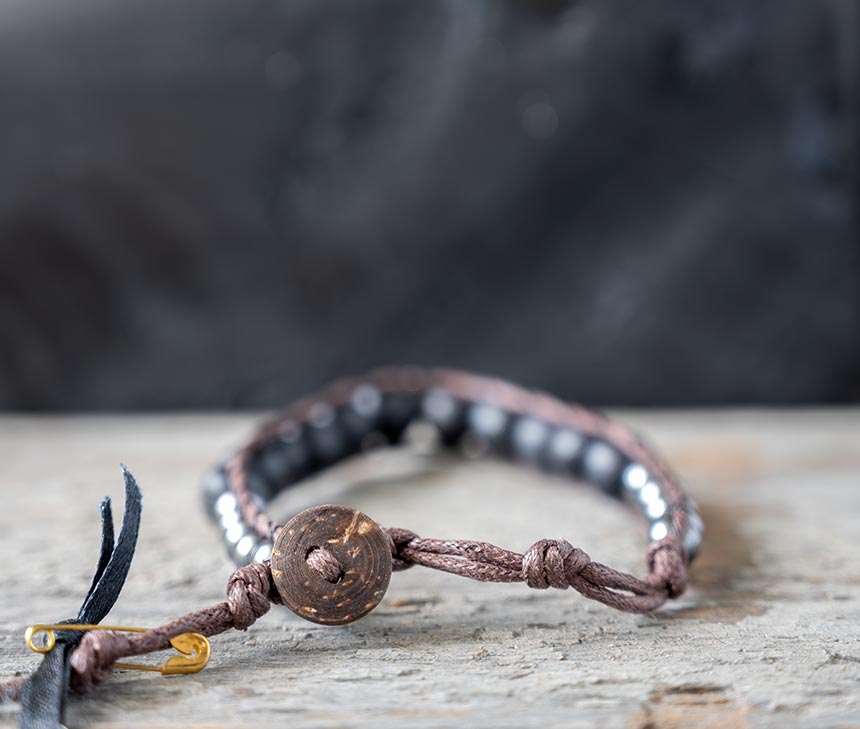 Back view of the Nomad Moonless Night men's bracelet by Lotus and Luna on a rustic wooden backdrop