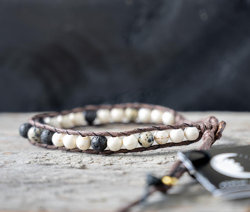 Side view of the Lotus and Luna Nopmad Pebble Crunch men's bracelet on a rustic wood backdrop