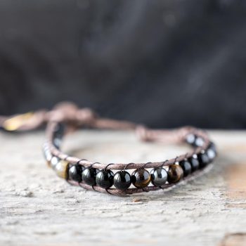 Front view of the Rajahs Lair Tigers Eye men's bracelet on a rustic wood backdrop
