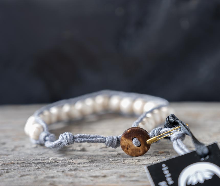 Back view of the Past the Breakers Surf Rider bracelet by Lotus & Luna against a rustic wood backdrop
