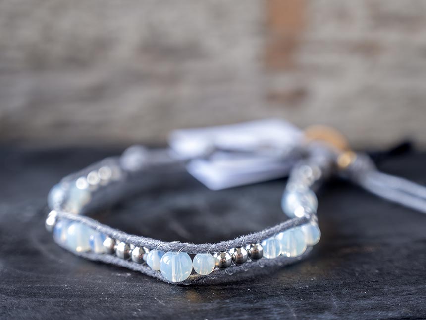 Front view of the women's Mermaid Blessings Moonstone bracelet by Lotus and Luna against a rustic wood backdrop