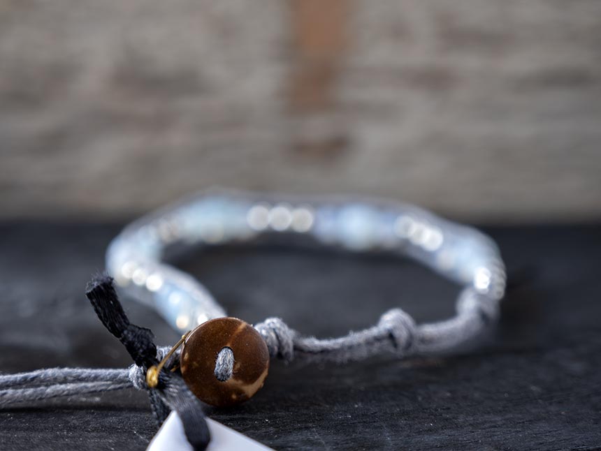 Back view of the women's Mermaid Blessings Moonstone bracelet by Lotus and Luna against a rustic wood backdrop