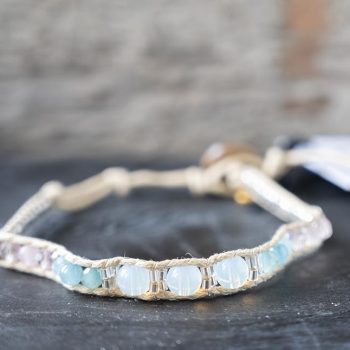 Front view of the Lotus and Luna Moonstruck Moonstone women's bracelet on a rustic wood backdrop