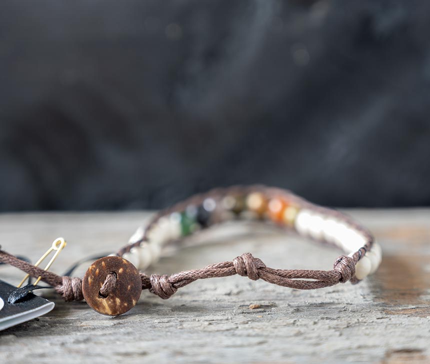 Back view of the Chakra CXhief Surf Rider bracelt by Lotus & Luna on a rustic backdrop