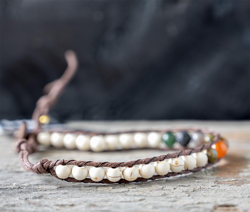 Side view of the Chakra Chief Surf Rider bracelt by Lotus & Luna on a rustic backdrop