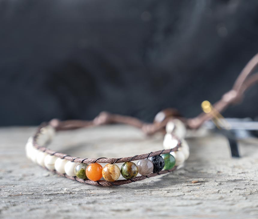 Front view of the Chakra CXhief Surf Rider bracelt by Lotus & Luna on a rustic backdrop