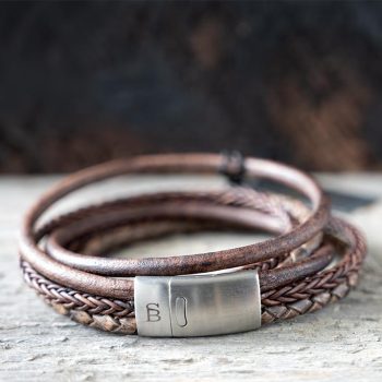 Front view of the brown leather Bonacci bracelet by Steel & Barnett on a rustic piece of wood and backdrop