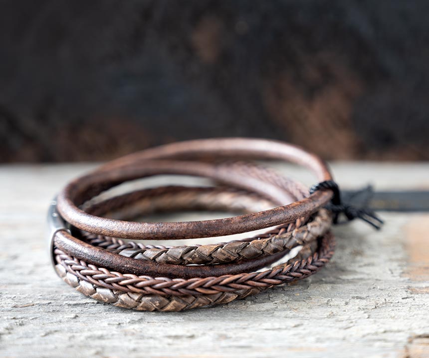 Left side view of the brown leather Bonacci bracelet by Steel & Barnett on a rustic piece of wood and backdrop