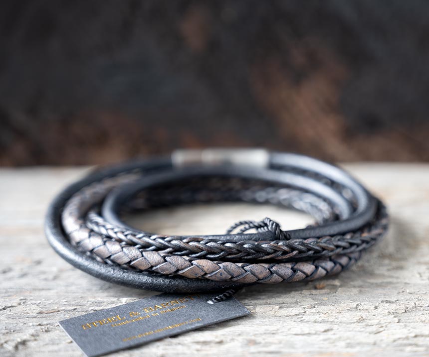 Back view of the navy leather Bonacci bracelet by Steel & Barnett on a rustic piece of wood and backdrop
