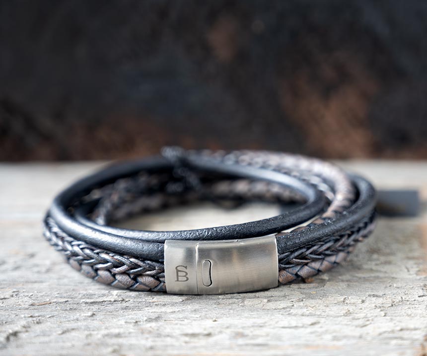 Front view of the navy leather Bonacci bracelet by Steel & Barnett on a rustic piece of wood and backdrop
