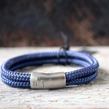 Front view of the Steel & Barnett Lake Rope Bracelet in navy on a rustic piece of wood and wood backdrop