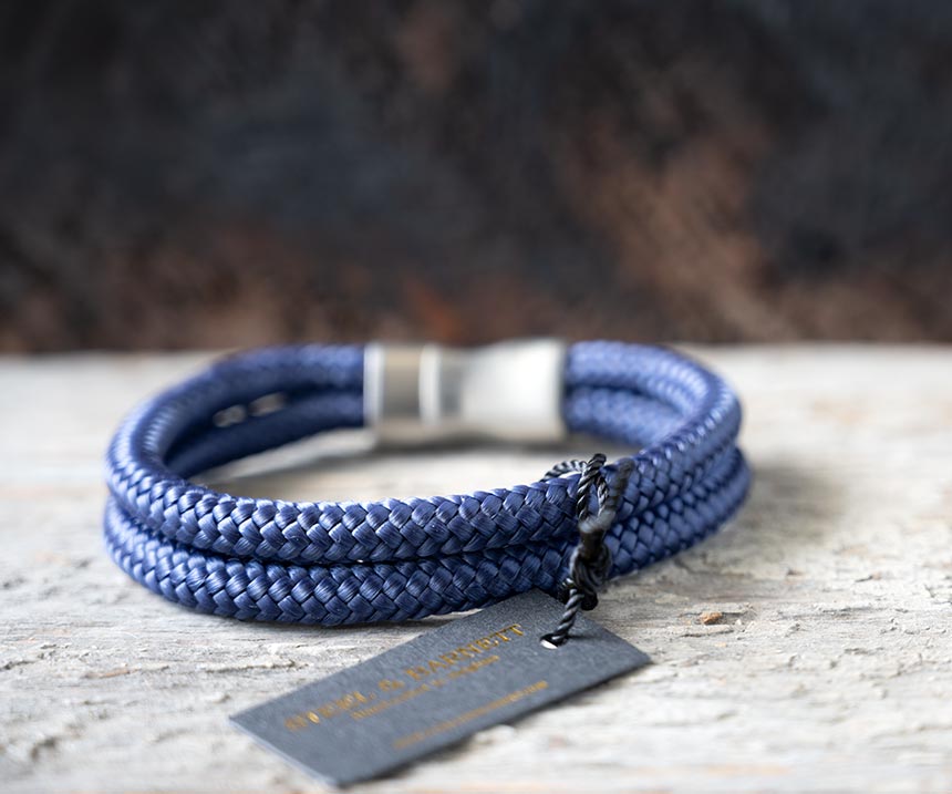 Back view of the Steel & Barnett Lake Rope Bracelet in navy on a rustic piece of wood and wood backdrop