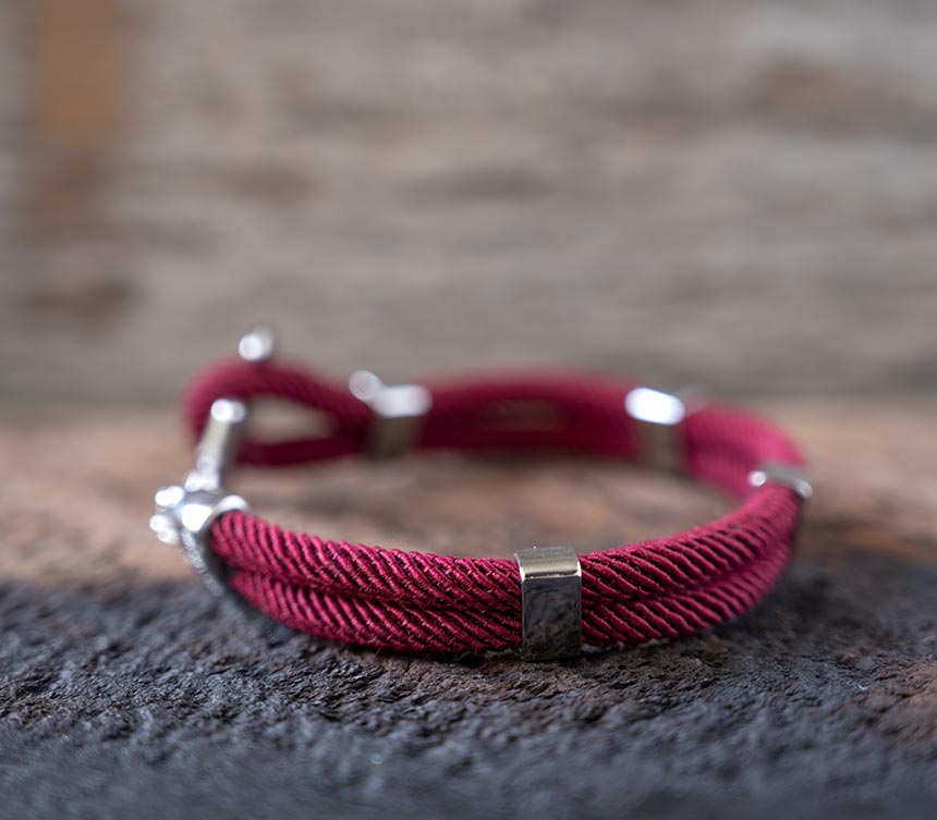 Left side view of the Women’s Maris Sal Nautical Anchored New Haven Bracelet in Bordeaux Bracelet on a Piece of Rustic Wood