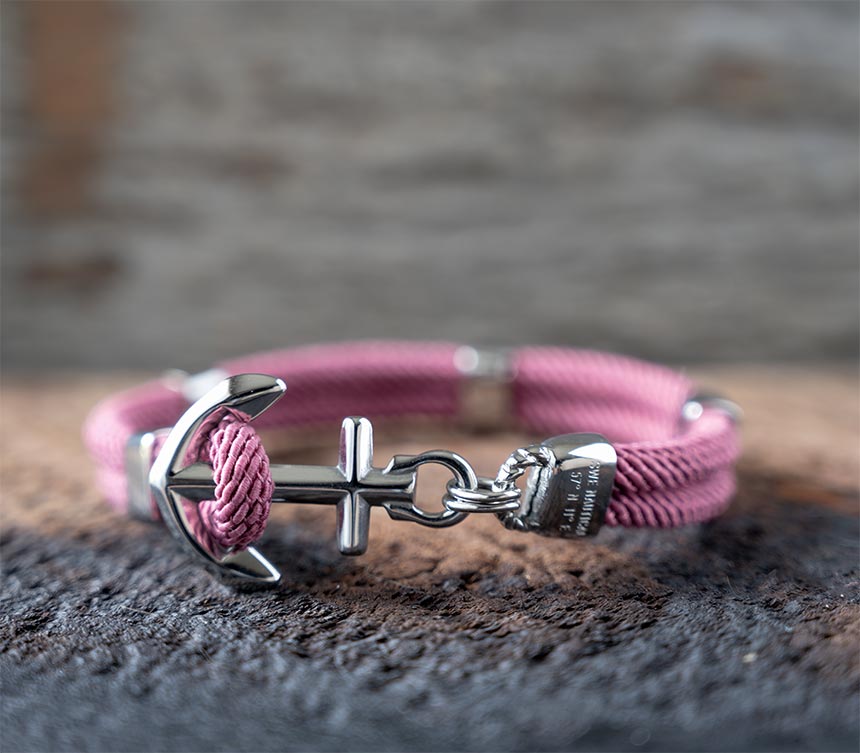 The Women’s Maris Sal Nautical Anchored New Haven Bracelet in Dusty Pink Bracelet on a Piece of Rustic Wood