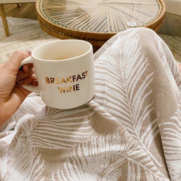 Women with a cup of coffee resting on her lap covered with a Turkish towel by Case+Drift