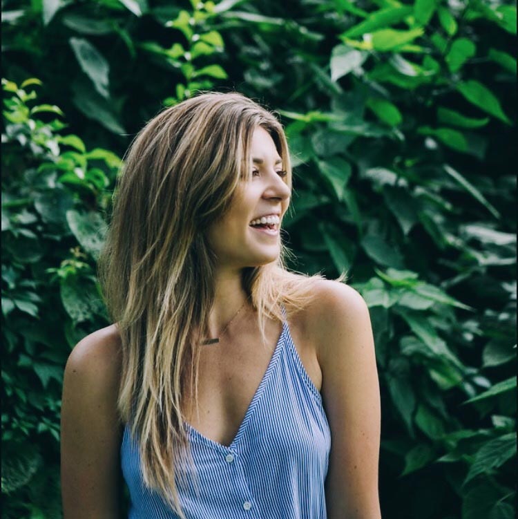 Picture of Casey Bagby, founder of the Turkish Towel Brand Case+Drift happy and smiling near tall shrubs