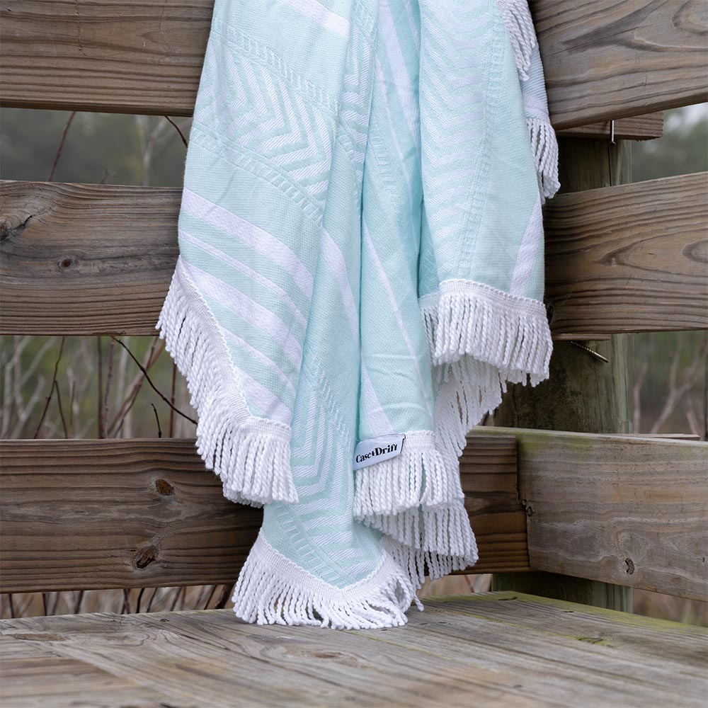Mint Octavia Turkish towel by Case_Drift draped over a boardwalk railing on a lake