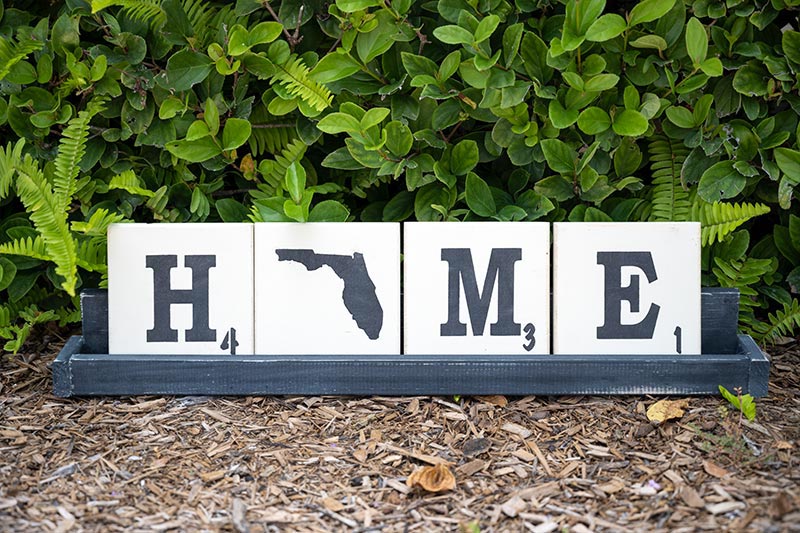 Wooden letter tile trays with the saying Home with the State of Florida as the O
