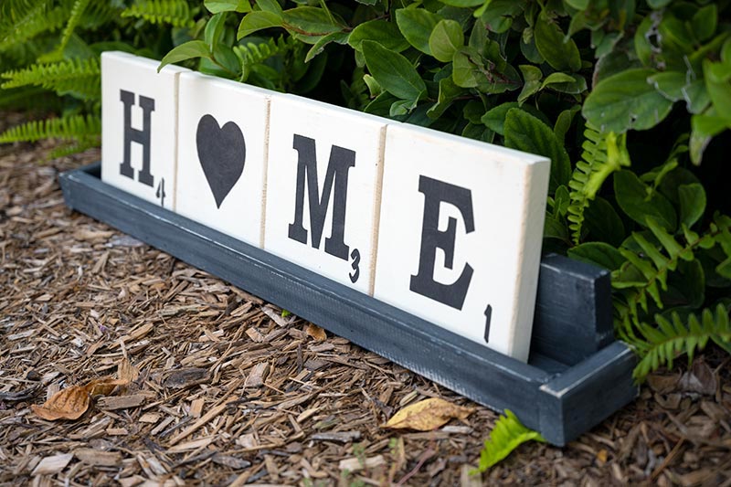 Angled view of the Wooden letter tile trays with the saying Home with a heart as the O