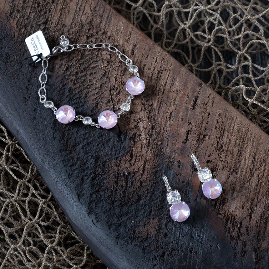 Top view of the perfect pairing of pink Swarovski earrings by VB&CO on a piece of wood