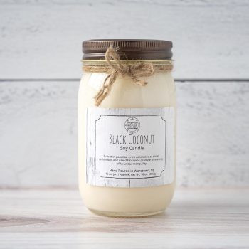 Coastal Threads Black Coconut Cabana Soy Candle on a beachwood top and white rustic wood background