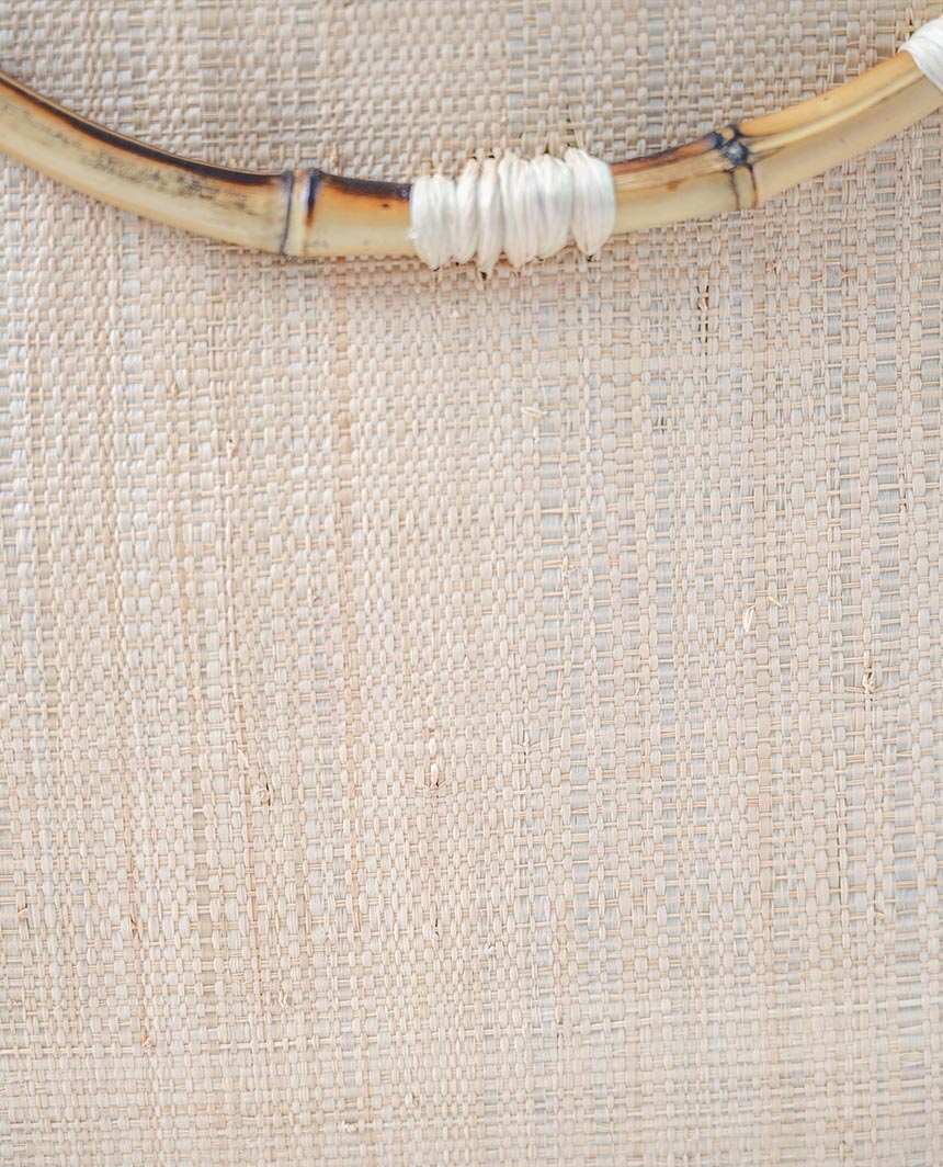 Closeup view of the textured fabric of the natural Shebobo Bebe straw bamboo women's handbag