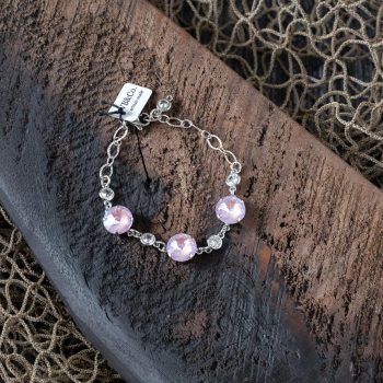 Top view of the pink Swarovski bracelet by VB&CO on a piece of wood