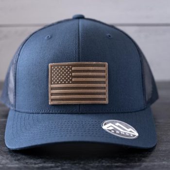 Front view of the RANGE Leather American Leather Patch Hat in navy against a wooden backdrop