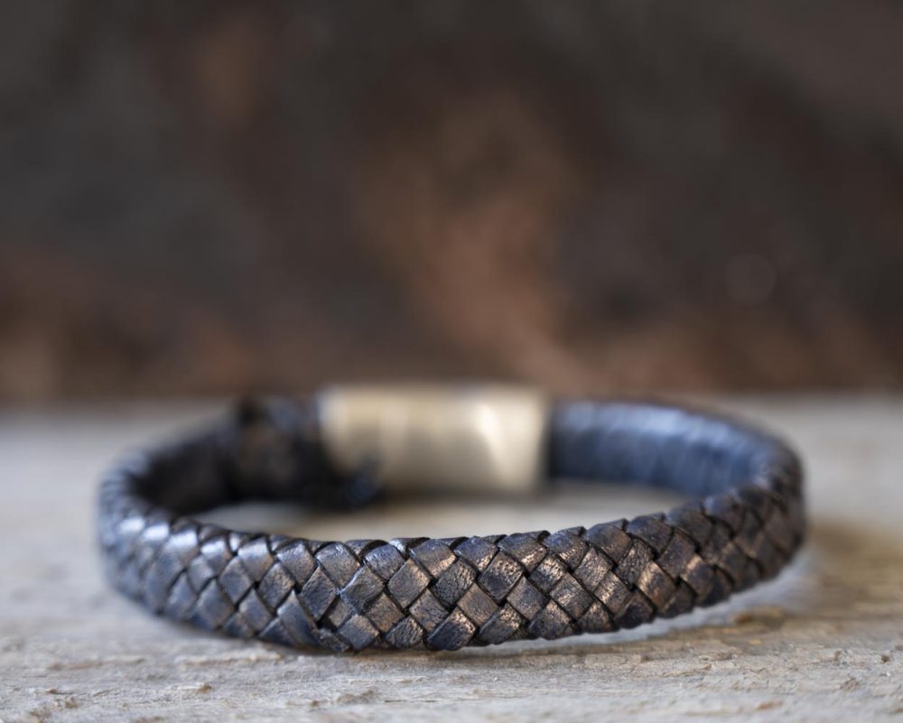 Back view of the Steel & Barnett Cornall bracelet in navy on and against a rustic wooden backdrop