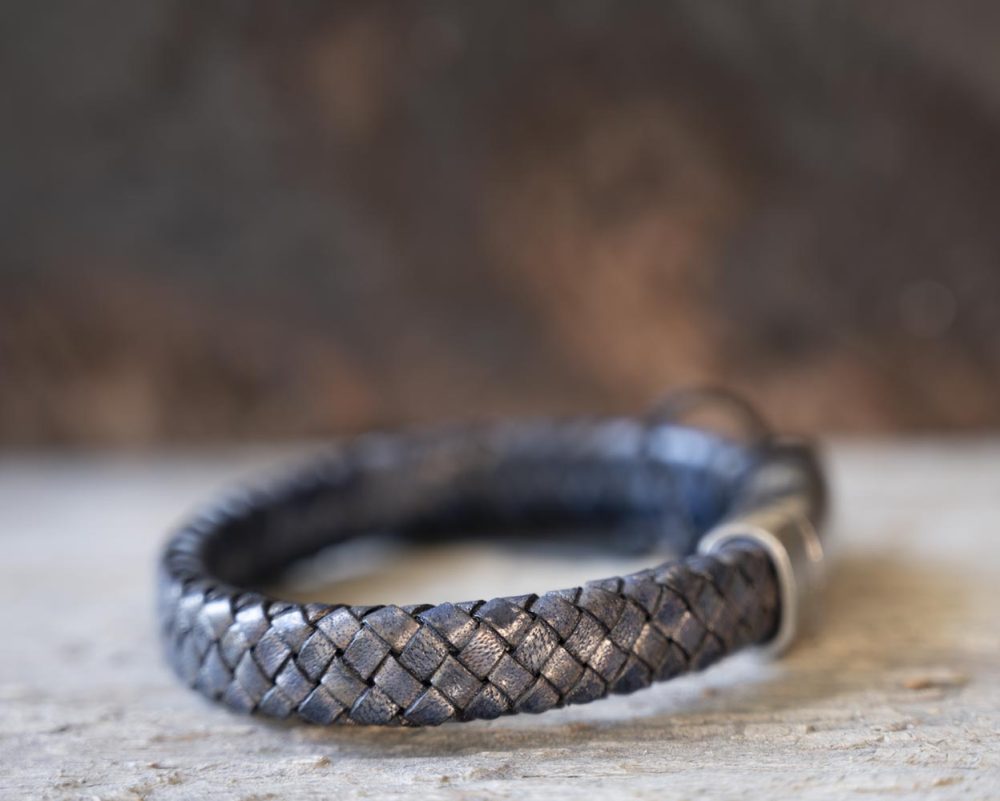 Right view of the Steel & Barnett Cornall bracelet in navy on and against a rustic wooden backdrop