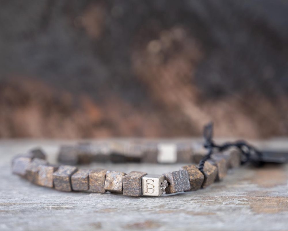 Front view of the bronzite stoned Memphis bracelet by Steel & Barnett on and against a rustic wood backdrop