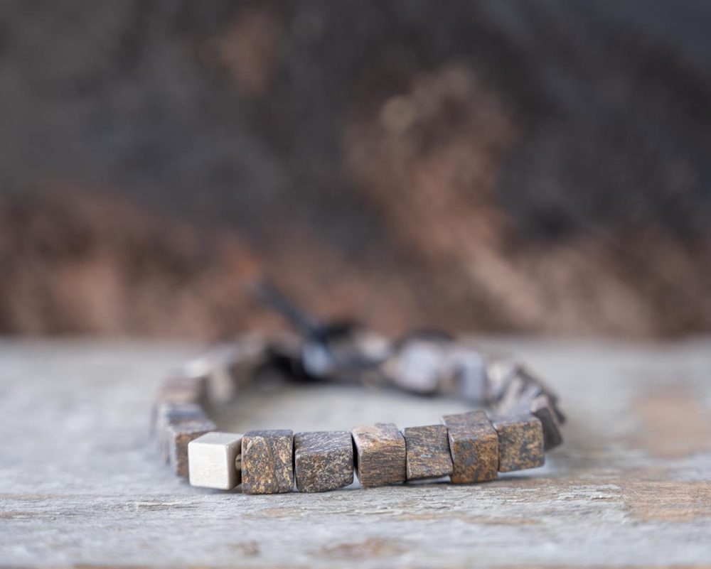 Back view of the stoned Memphis bracelet in bronzite by Steel & Barnett on and against a rustic wood backdrop