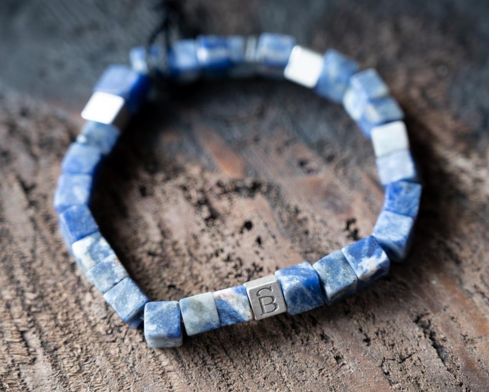 Top View front view of the stoned Memphis bracelet in navy by Steel & Barnett on and against a rustic wood backdrop