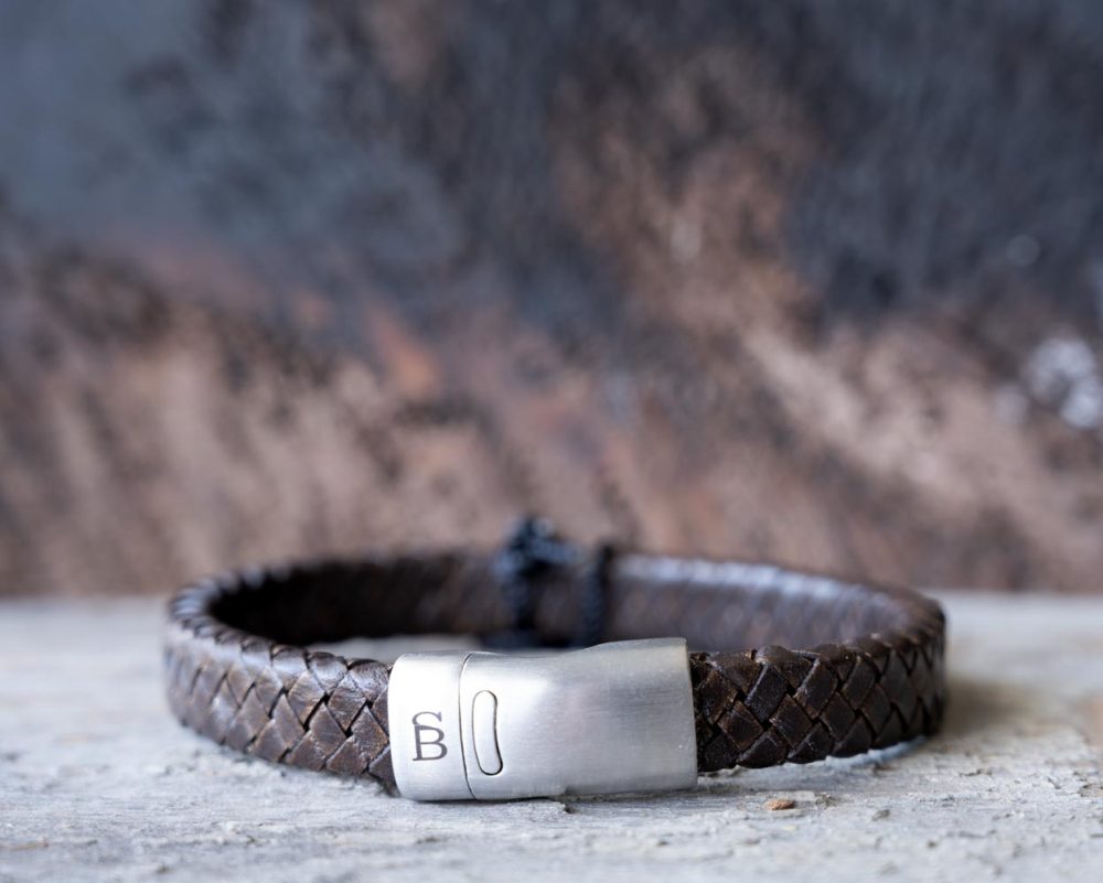 Front view of the Steel & Barnett Cornall bracelet in Vintage Brown on and against a rustic wooden backdrop
