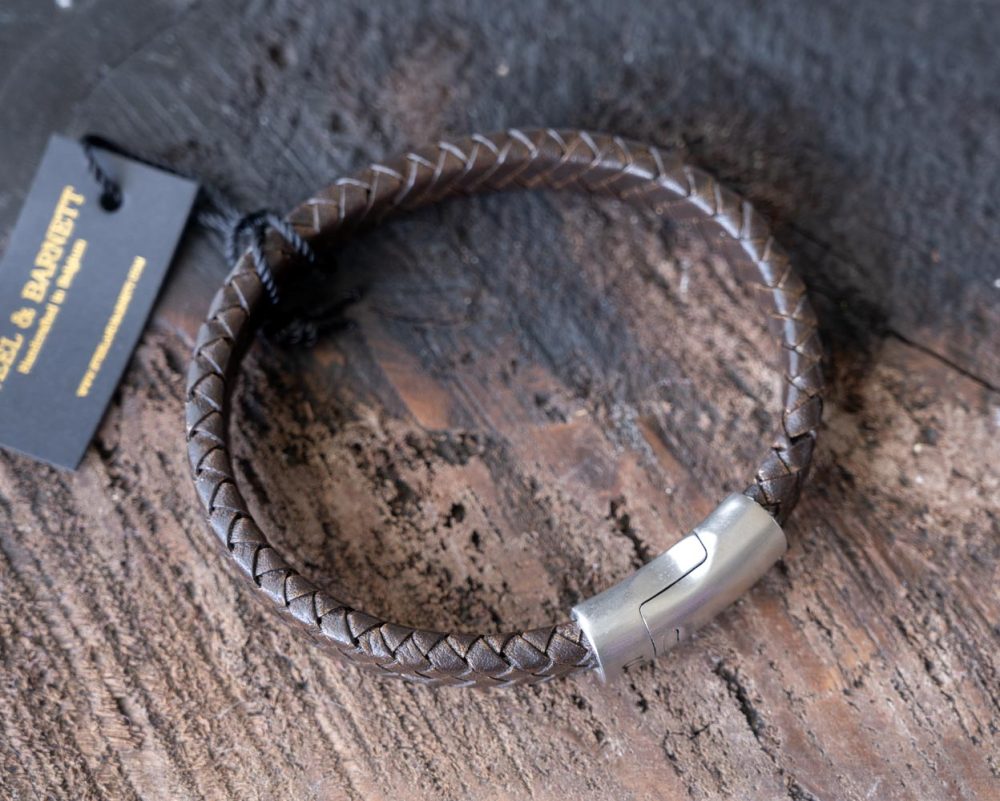 Top view of the Steel & Barnett Cornall bracelet in Vintage Brown on and against a rustic wooden backdrop