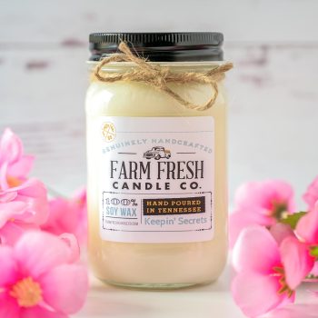 View of the Farm Fresh Candle Co Keepin' Secrets candle with Spring props and rustic backdrop