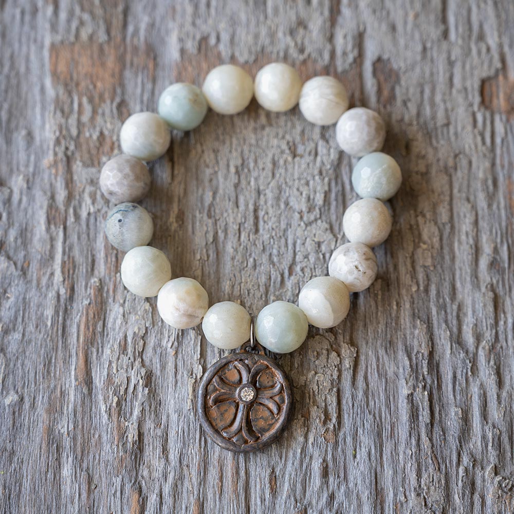 Top view of the VB&CO Beaded Amazonite Bracelet with Cross and Crystal Charm on Rustic Wood