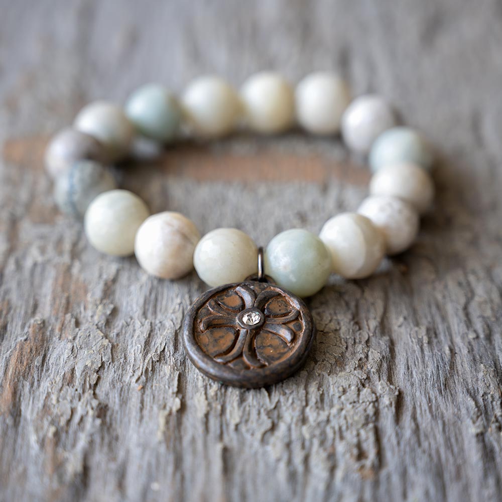 Closeup Front view of the VB&CO Beaded Amazonite Bracelet with Cross and Crystal Charm on Rustic Wood