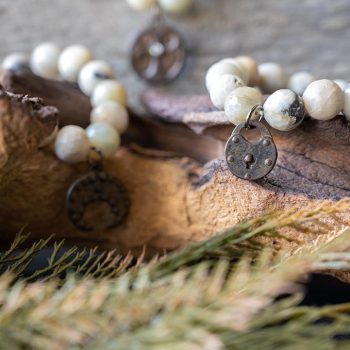 The VB&CO Amazonite Beaded Bracelet with Charms Collection with leaves and rustic wooded backdrop
