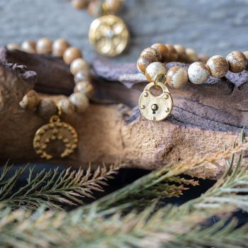 The VB&CO Designs Jasper beaded bracelet collection with leaves and wood backdrop