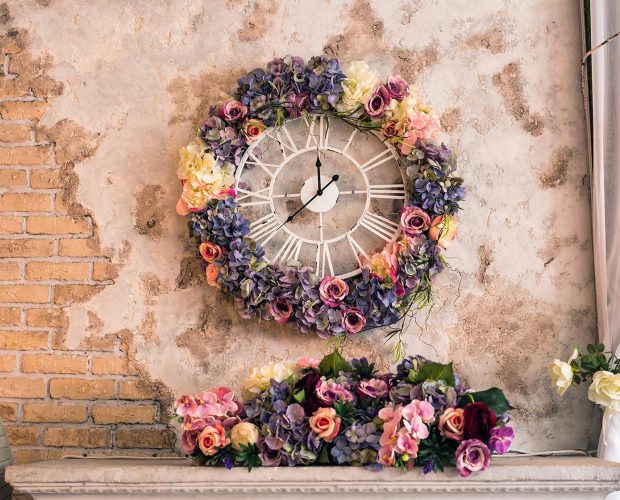 Rustic Wall with Clock and floral arrangements around the clock