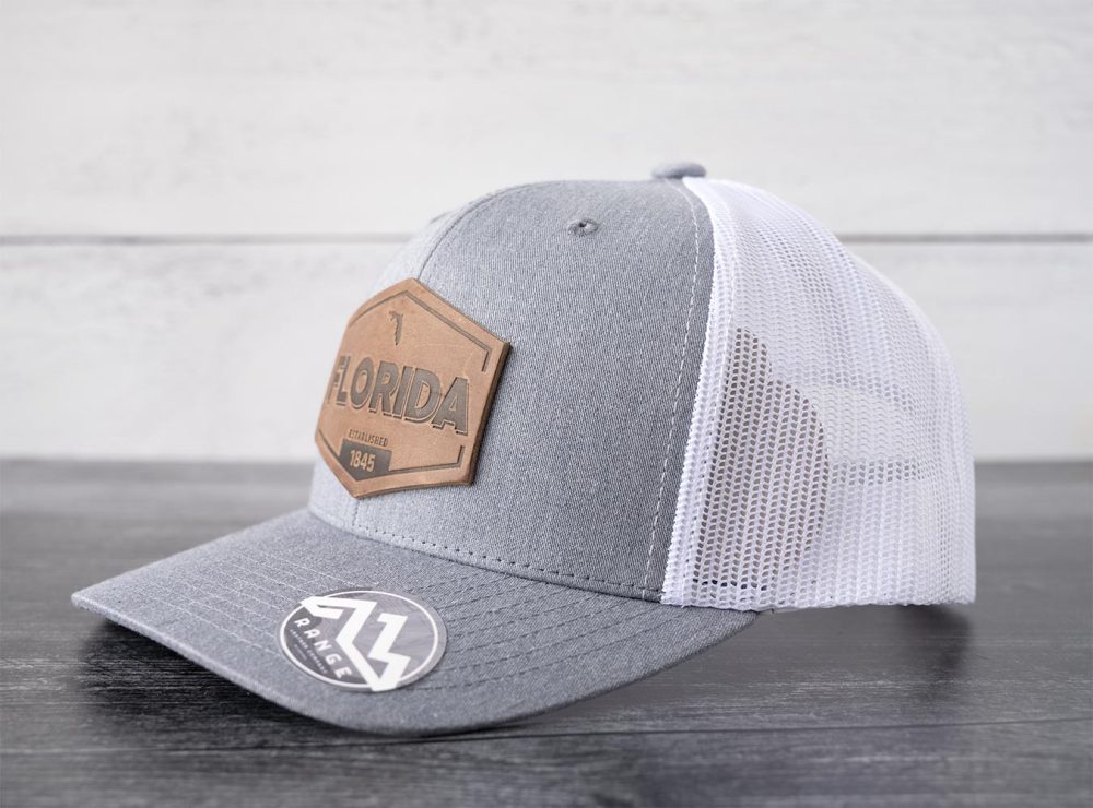 Left side view of the RANGE Leather Florida Established hat in heather gray & white on and against a rustic wood backdrop