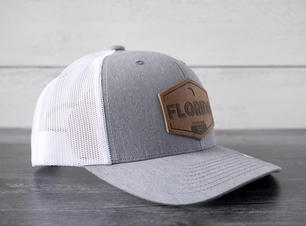 Right side view of the RANGE Leather Florida Established hat in heather gray & white on and against a rustic wood backdrop