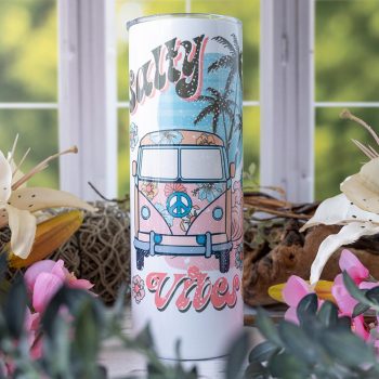 Emma K Designs Beach Vibes Skinny 20 oz. tumbler on rustic backdrop with window and flowers
