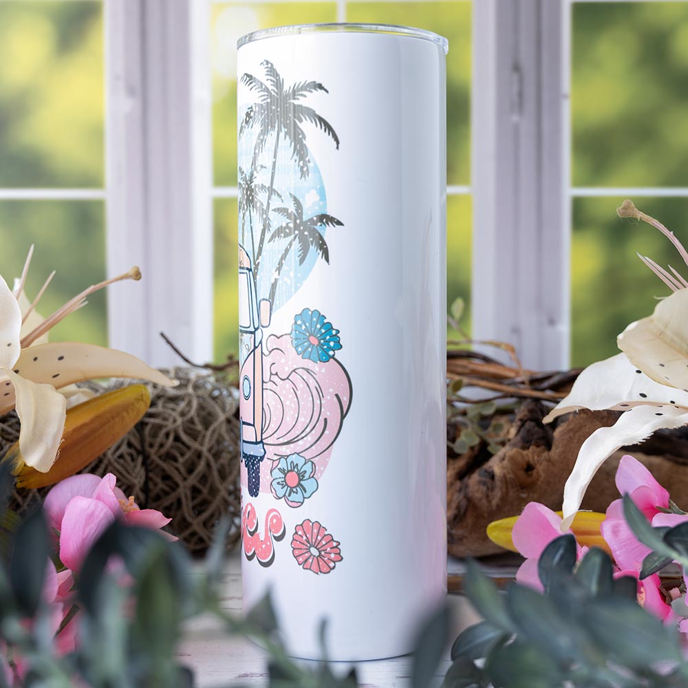 Left view of the Emma K Designs Beach Vibes Skinny 20 oz. tumbler on rustic backdrop with window and flowers