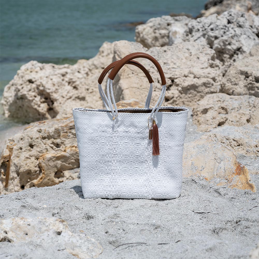 Front View of the Mavis by Herrera Hannah Resort Tote Bag in the Color Pearl White at the Beach